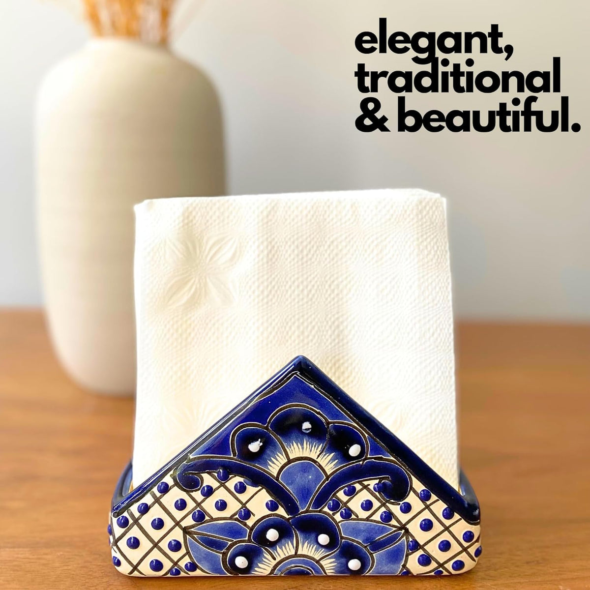 Blue and white Talavera-style ceramic napkin holder, hand-painted in Mexico — styled on a wood table with a folded napkin and a vase