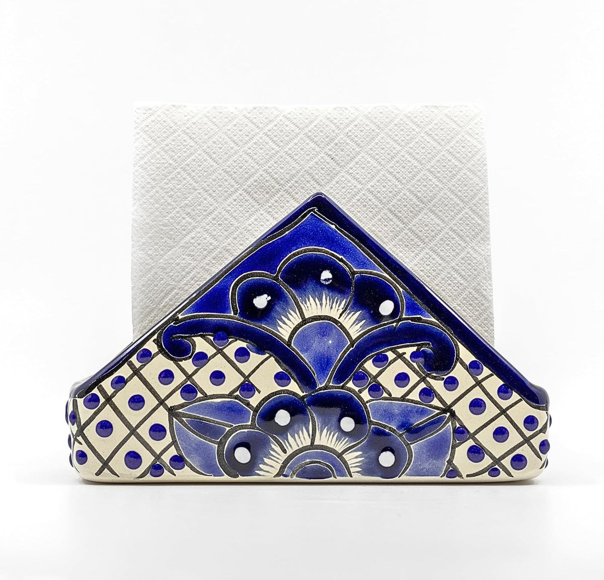 Blue and white Talavera-style ceramic napkin holder, hand-painted in Mexico — holding a folded white dinner napkin