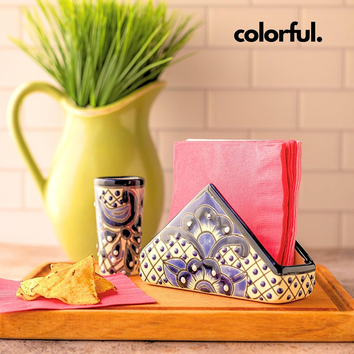 Blue and white Talavera-style ceramic napkin holder, hand-painted in Mexico — on a kitchen counter with pink napkins, tortilla chips and a hand-painted