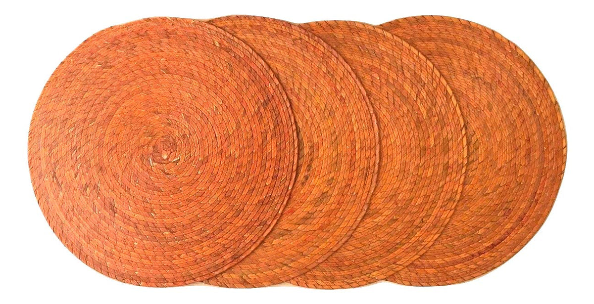 Orange round woven palm placemats set of 4, handmade Mexican table decor — top view
